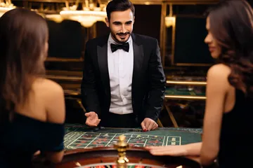 A professional dealer in a tuxedo greeting players at the roulette table, symbolizing the authentic live casino feel at LUCK789.